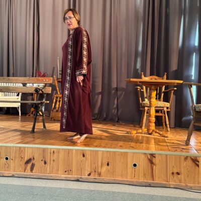 aktorka w bordowej sukni na scenie