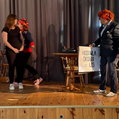 aktorzy z plakatem na scenie