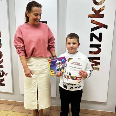 Pani Dyrektor Magdalena Dubińska wręcza nagrodę chłopcu-klocki lego i dyplom