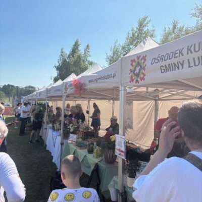 Szereg stoisk konkursowych na zupę. Ludzie przy stoiskch.