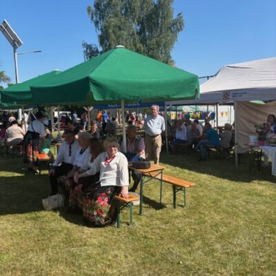 Ludzie siedzący pod namiotami i oglądający występy.