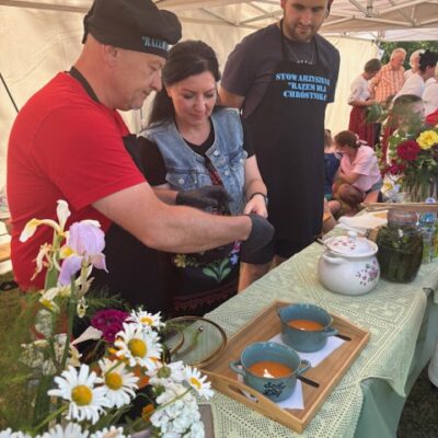 Kucharz z pomocą przygotowuje zupę do smakowania.