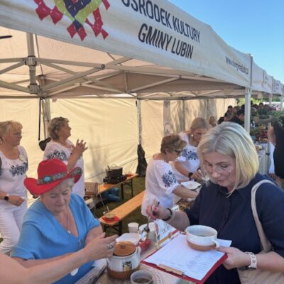 Kobieta z jury zapisuje wyniki na kartce.