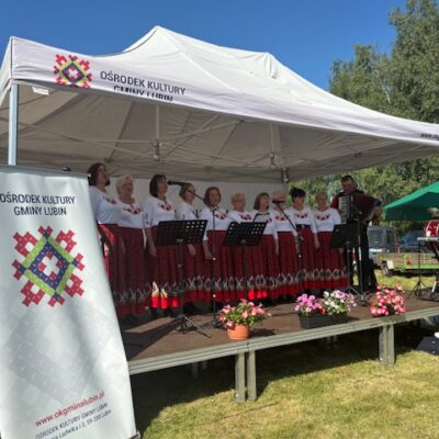 Zespół zachęta na scenie w ludowych strojach