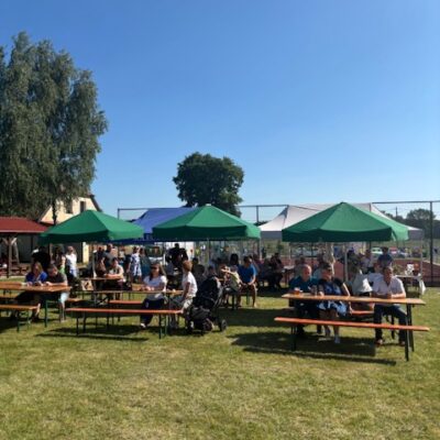 Ludzie siedzący pod namiotami i oglądający występy.