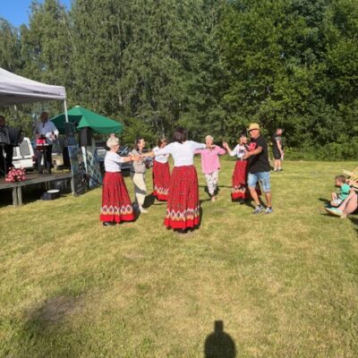 Kobiety z koła tańczą z sołtysem pod sceną.