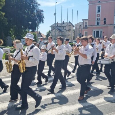 Muzycy w korowodzie jeden za drugim idą i grają