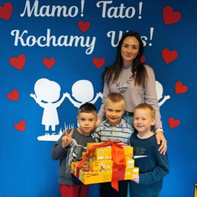 Wychowawczyni z laureatami konkursu. Trzech chłopców trzyma duże zestawy lego