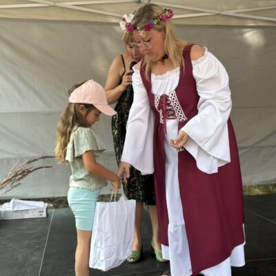 dziewczynka odbiera od kobiety nagrodę na scenie