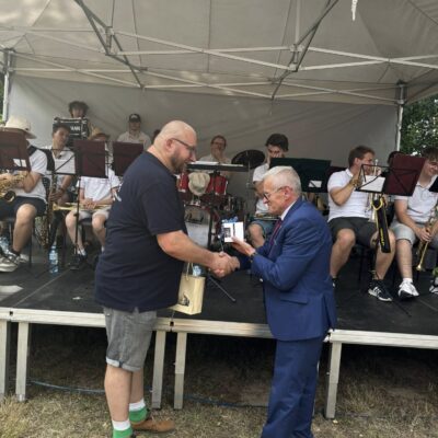 kapelmistrz odbiera podziękowanie od prezesa chórów i orkiestr
