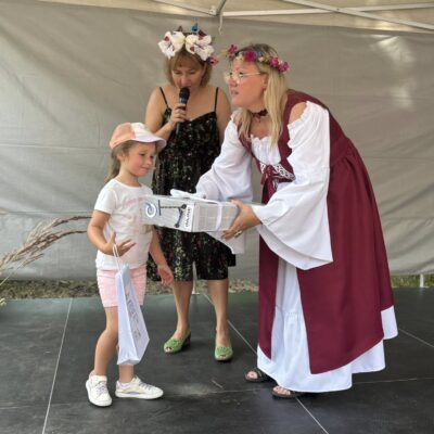 dziewczynka odbiera od kobiety nagrodę na scenie