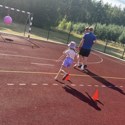 dziewczynka na boisku przebiega tor pezeszkód