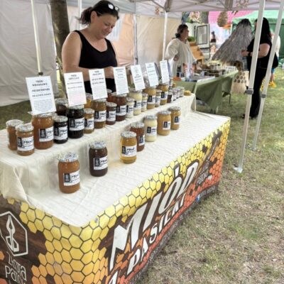 stoisko z miodami a za ladą stoi kobieta