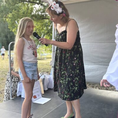 dziewczynka odbiera od kobiety nagrodę na scenie