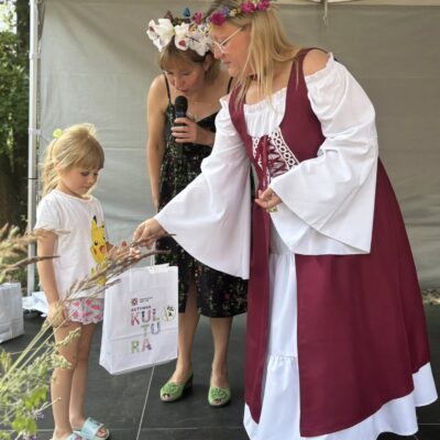 dziewczynka odbiera od kobiety nagrodę na scenie