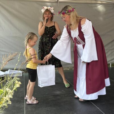 dziewczynka odbiera od kobiety nagrodę na scenie