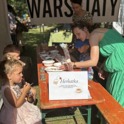 ludzie pod namiotem z warsztatami robią receptury herbat