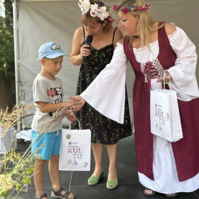 chłopczyk odbiera nagrodę od kobiety na scenie