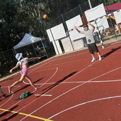 dziewczynka na boisku przebiega tor pezeszkód i rzuca do bramki