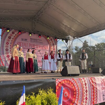 zespół na scenie śpiewa kobiety i meżczyńi