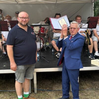 wreczenie podziękowania dla orkiestry od prezesa chórów i orkiestr