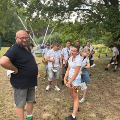 orkiestra przed występem na pierwszym planie uśmiechnięty kapelmistrz