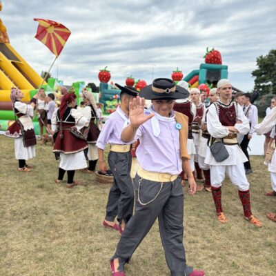 mężczyzna w kapeluszu macha ręką