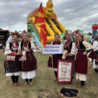 kobietyz macedonii w sukniach bordowych i flagą