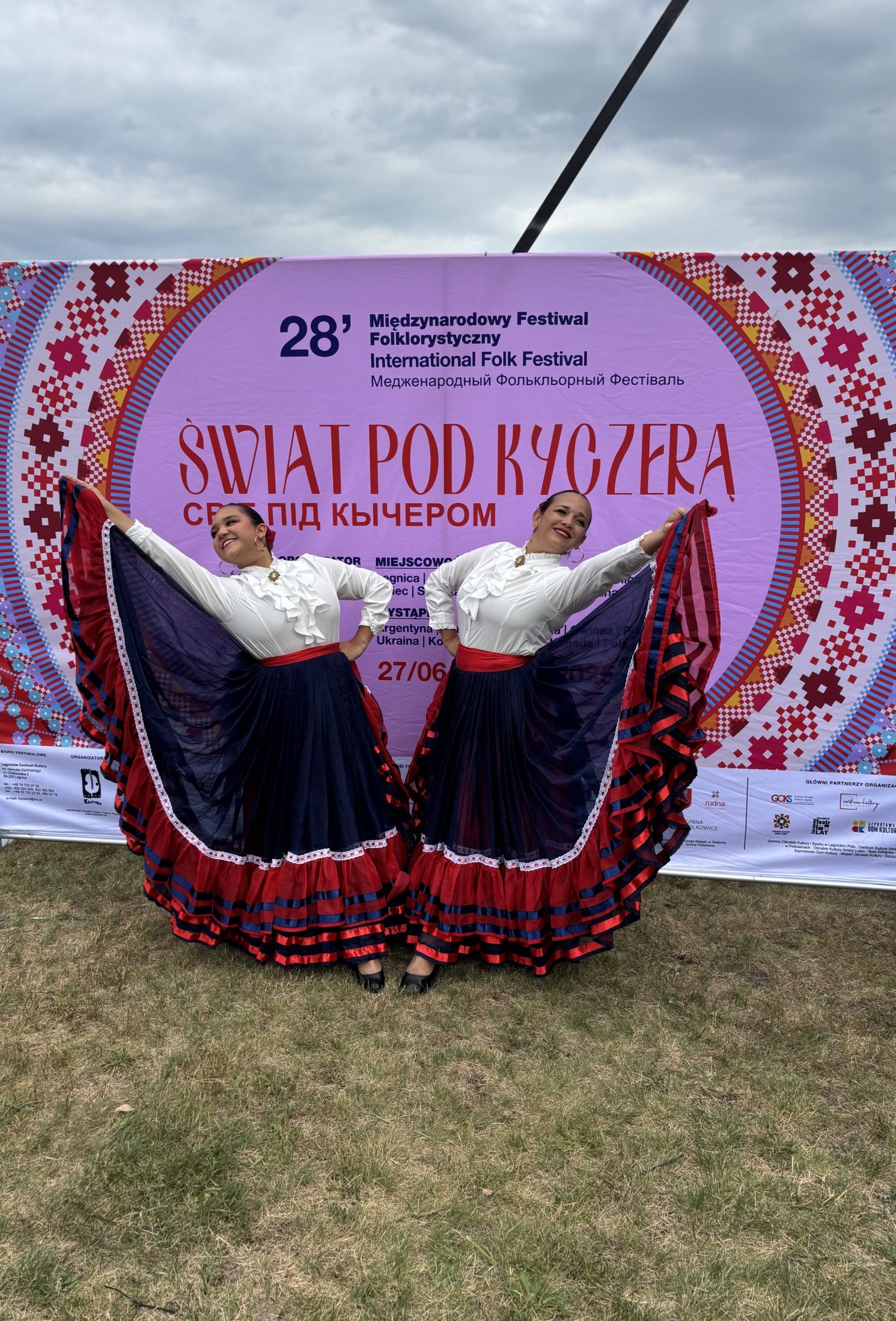 kobiety z kostaryki pozują w sukniach na tle baneru swiat pod kyczerą