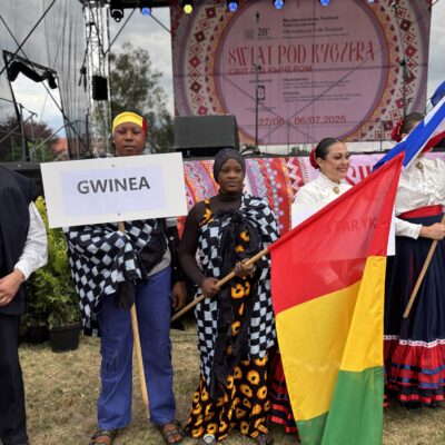 gwinea przed sceną z flagą