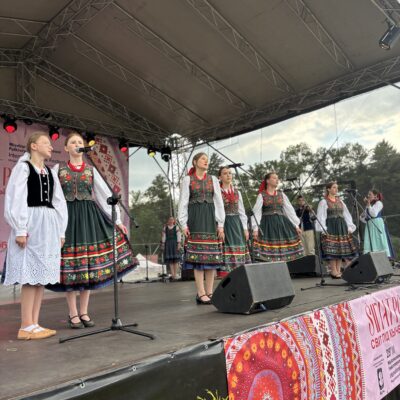 zespuch na scenie w ludowych strojach spiewa