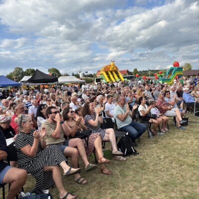 duża grupa ludzi ogląda występy, siedza na krzesłach