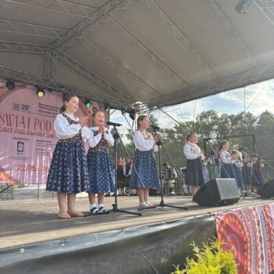 Dzieci grają na skrzypcach i spiewają na scenie