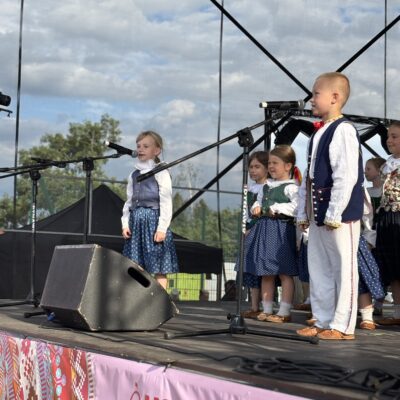 chłopczykz dziewczynką przy mikrofonie śpiewają w tle dzieci