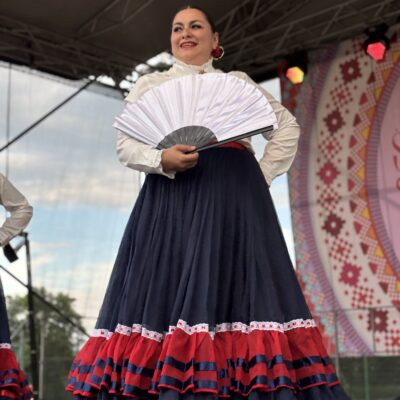 kobieta stoi na scenie i trzyma wachlarz