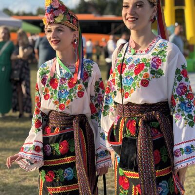 dwie kobiety w wiankach i sukniach kolorowych