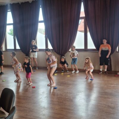 dzieci podczas zajęć stoją i sluchają instruktorki