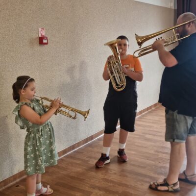 instruktor z dziećmi i instrumentami dętymi