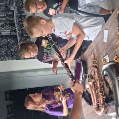 dzieci oglądają instrumenty dęte leżące na stoliku