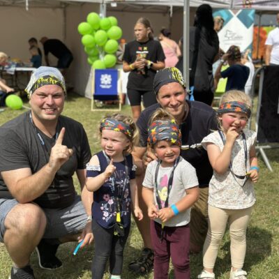 rodzina pozuje do zdjęcia po przebiegnięciu trasy, uśmiechają się