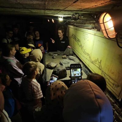 dzieci pod ziemią w kopalni słuchają przewodnika