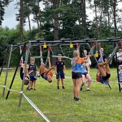 grupa ludzi na torze przeszkód w zwisie