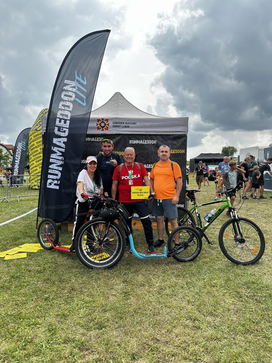 Zawodnicy z rowerami na ściance do zdjęć