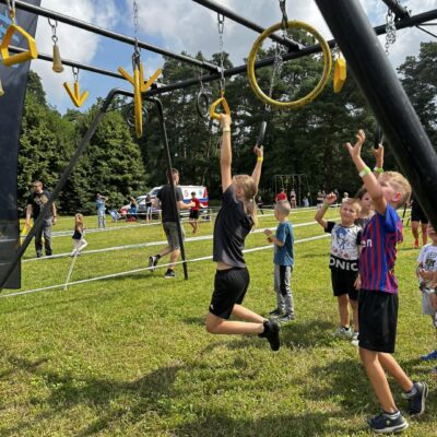 grupa ludzi na torze przeszkód w zwisie