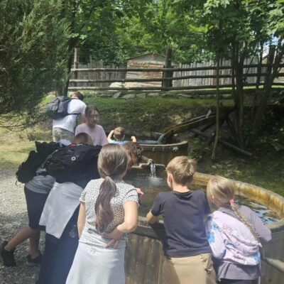 dzieci wpatrują się w wode w drewnianym zbiorniku