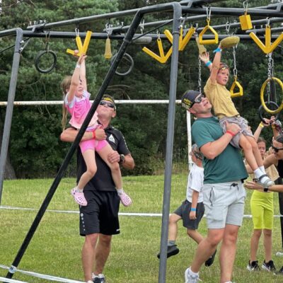 grupa ludzi na torze przeszkód w zwisie