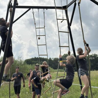 uczestnicy na przeszkodzie drabinki, wspinają się