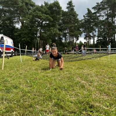 dziewczynka wychodzi spod przeszkody siatki