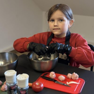 dziewczynka w fartuszku wrzuca składniki do miski