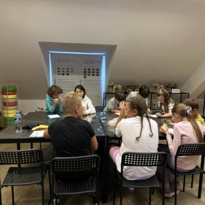 dzieci siedzą przy stołach i jedzą podczas przerwy